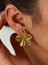 Femme portant les boucles d’oreilles florales Assinie en acier inoxydable
