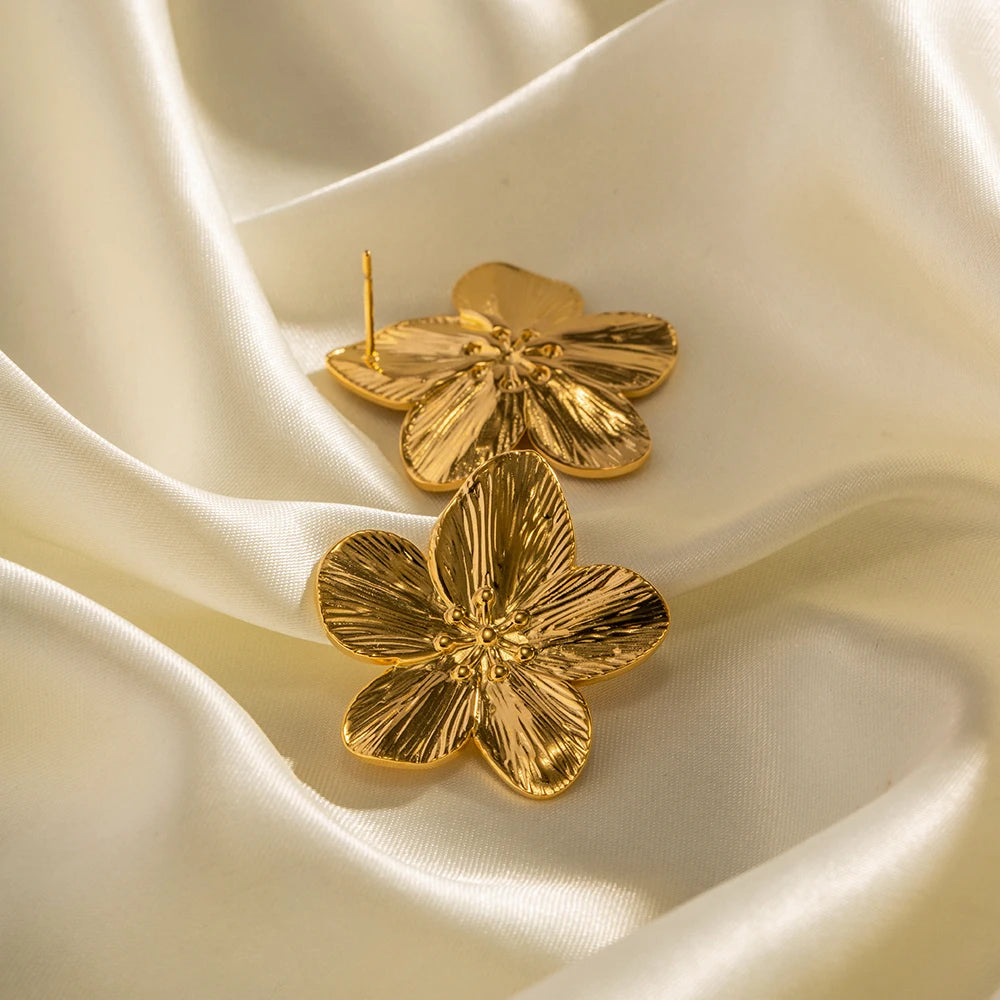 Détails des boucles d’oreilles dorées modèle Assinie, design fleur
