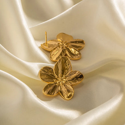 Détails des boucles d’oreilles dorées modèle Assinie, design fleur
