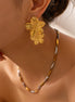 Femme portant les boucles d’oreilles florales Zanzibar en acier inoxydable
