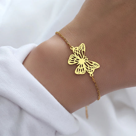Bracelet Jakarta en acier inoxydable doré avec pendentif papillon ajouré. O-dace.com