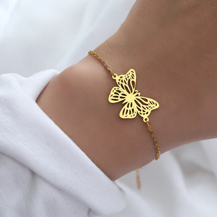 Bracelet Jakarta en acier inoxydable doré avec pendentif papillon ajouré. O-dace.com