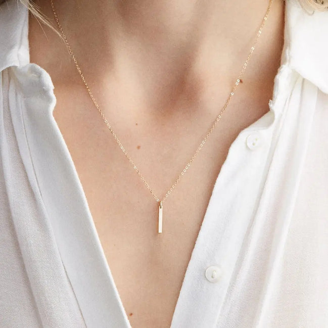 Collier Padang en acier inoxydable doré avec pendentif barre. O-dace.com