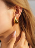 Boucles d’oreilles Kayes dorées en acier inoxydable portées sur une oreille. 25mm